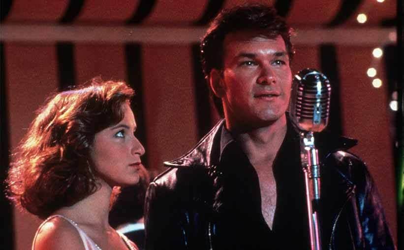 Jennifer Grey and Patrick Swayze on stage behind the microphone in Dirty Dancing 