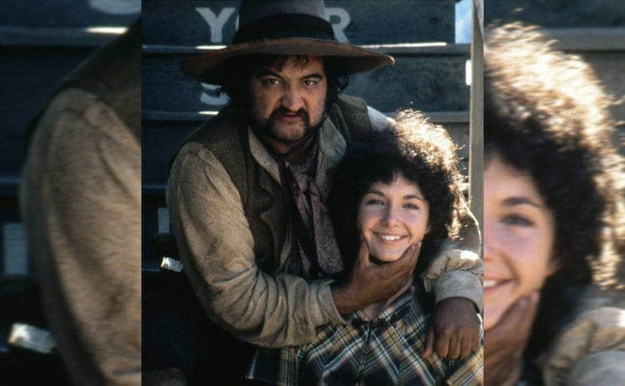 John Belushi posing behind Mary Steenburgen holding her chin on the set of Goin’ South 