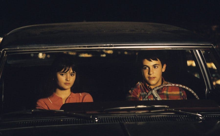 Fred Savage and Danica McKellar are sitting in a car in a still from the last season of The Wonder Years. 