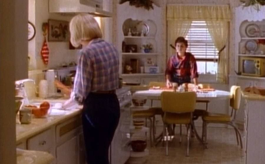 Mills and Savage are talking in the kitchen in a scene from The Wonder Years 