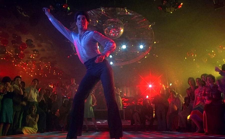 John Travolta, as Tony Manero, busting a movie on the dance floor. 