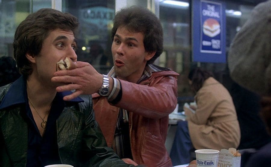 Paul Pape is shoving a burger into Joseph Cali’s mouth. 