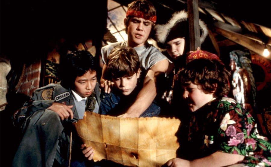 Josh Brolin is pointing something out on the map in a scene from ‘The Goonies’.