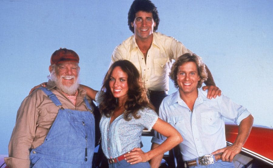 Denver Pyle, Catherine Bach, Byron Cherry, and Christopher Mayer in a promotional portrait of the television show's cast, circa 1982.