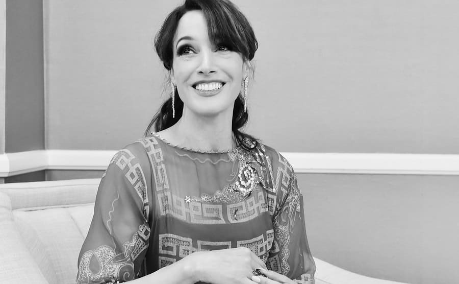 Jennifer Beals is sitting and smiling at the camera during the 22nd Costume Designers Awards at the Beverly Hilton Hotel, circa 2020.