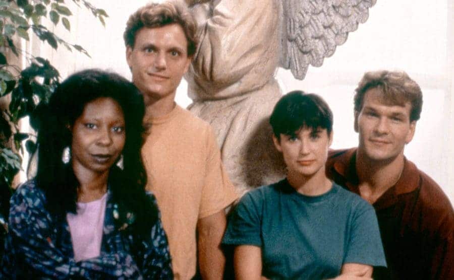 Actors Whoopi Goldberg, Tony Goldwyn, Demi Moore, and Patrick Swayze are posing for a photo on the set of Ghost.