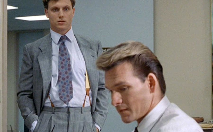 Movie still of Patrick Swayze sitting in his office when Tony Goldwyn enters.