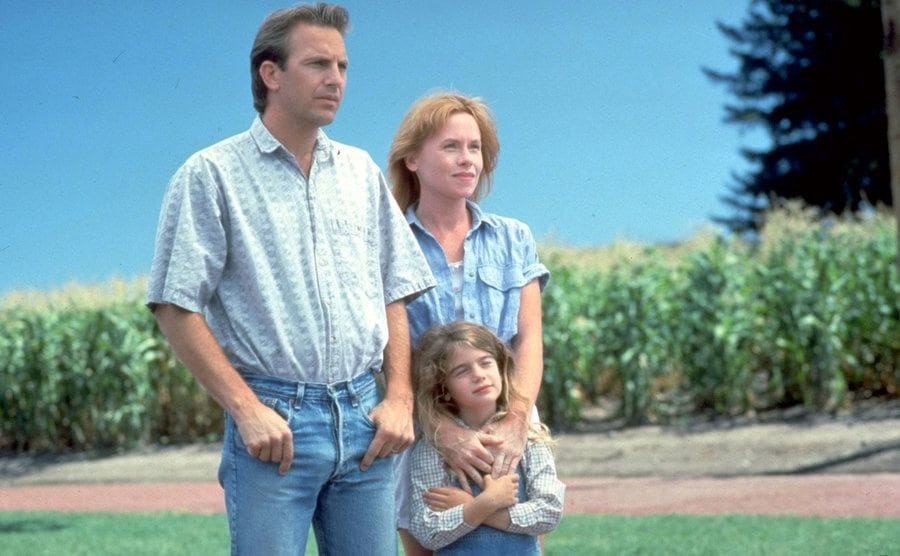 Costner, Madigan, and Hoffmann pose together as a family in a still from Field of Dreams. 