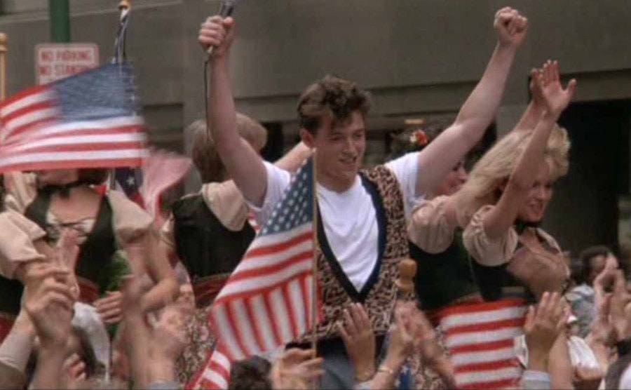 The crowd cheers for Ferris in the iconic parade scene from the movie.