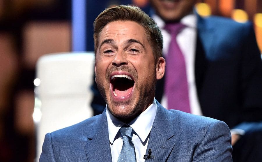 Rob Lowe is laughing onstage during The Comedy Central Roast of Rob Lowe.