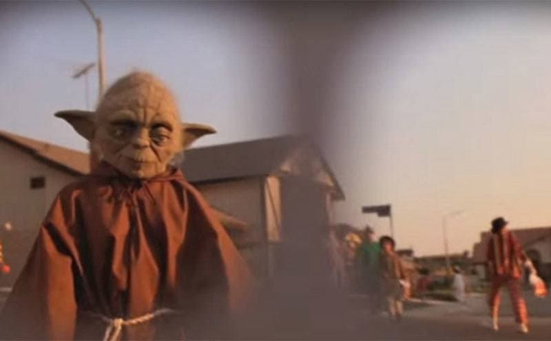 E.T. spots a boy in a Yoda costume from beneath his ghost costume. 