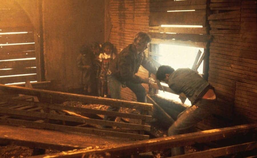 A still of Ralph Macchio and C.Thomas Howell trying to break into the burning church. 