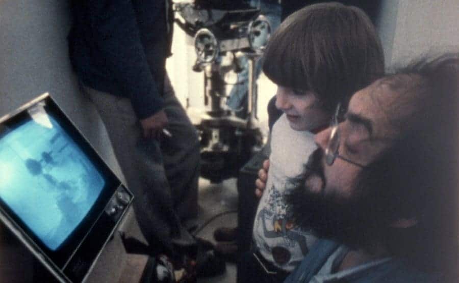 Danny Lloyd and Stanley Kubrick are watching a take playback on set. 