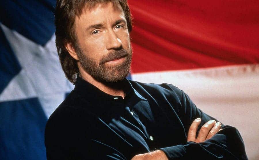 Chuck Norris stands before the Texas flag in a still from the show.