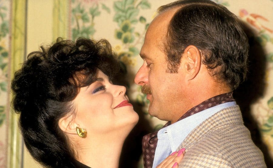 Delta Burke and Gerald McRaney is behaving romantically at an event. 