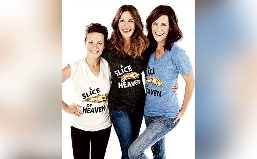 Roberts, Taylor, and Gish pose together, wearing the same t-shirts they wore as uniforms in the film Mystic Pizza. 