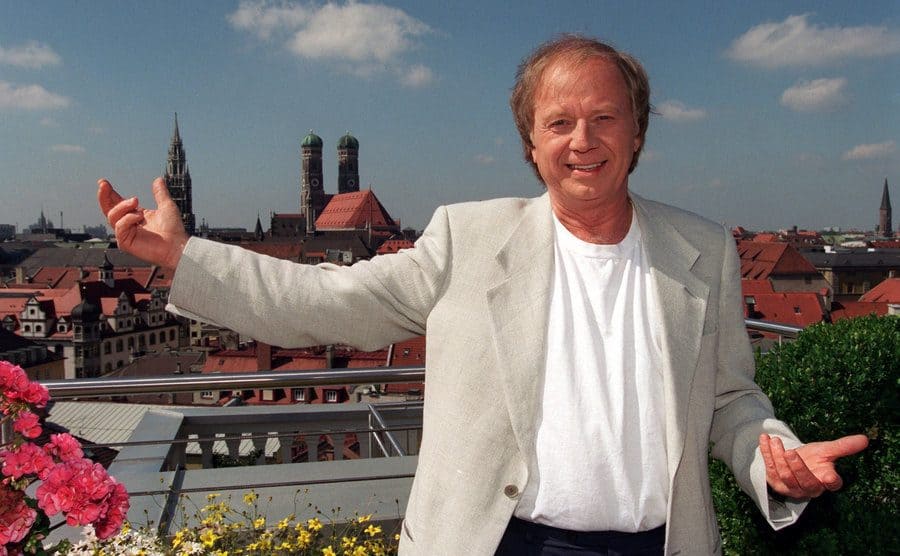A portrait of Wolfgang Peterson standing on a balcony. 