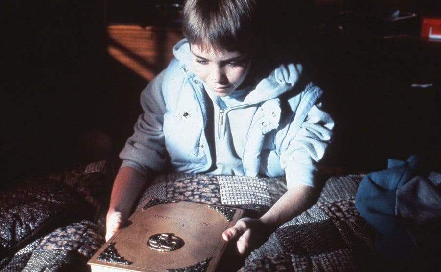 Jonathan Brandis sits in bed gazing at The Neverending Storybook.