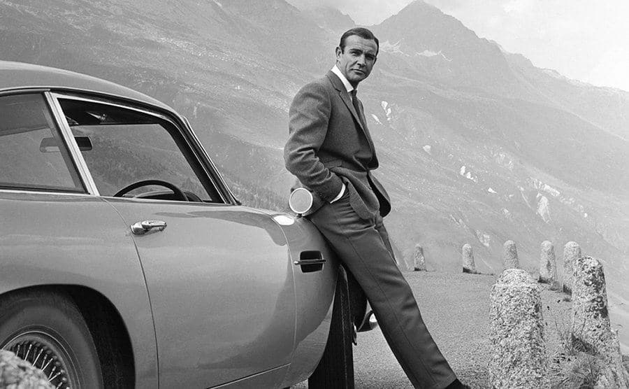 Sean Connery poses as James Bond next to his Aston Martin DB5.