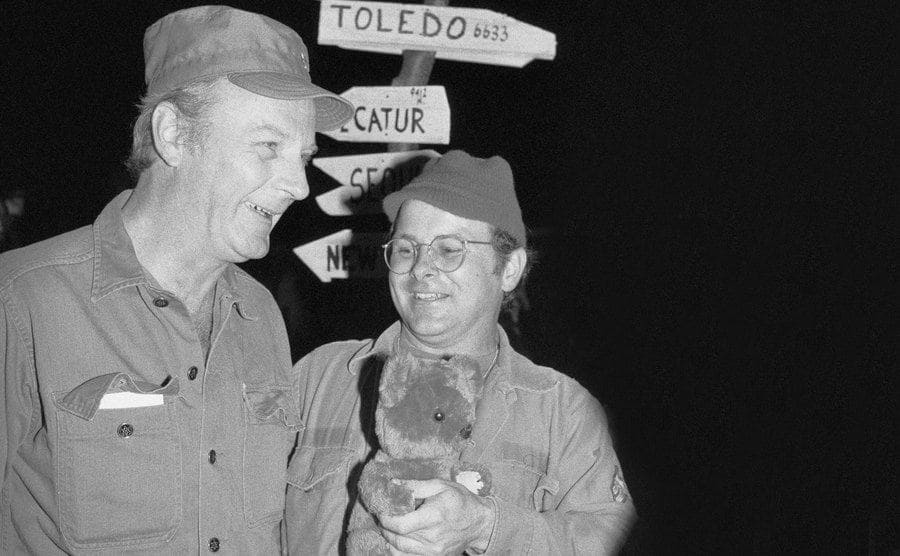 Larry Linville with Gary Burghoff, who is holding his teddy bear. 