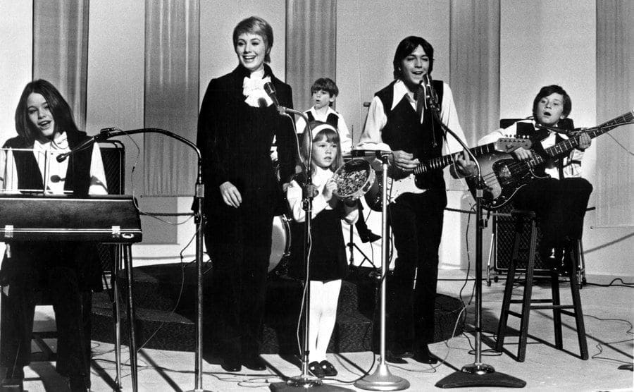 The Partridge family is playing their instruments in a scene from the show. 