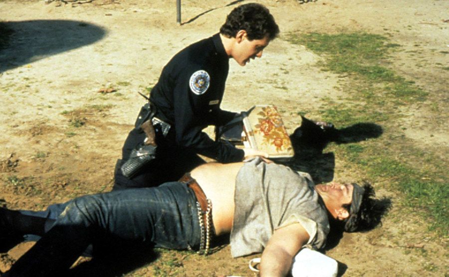 Steve guttenberg tending to someone on the floor on the set of The Police Academy. 
