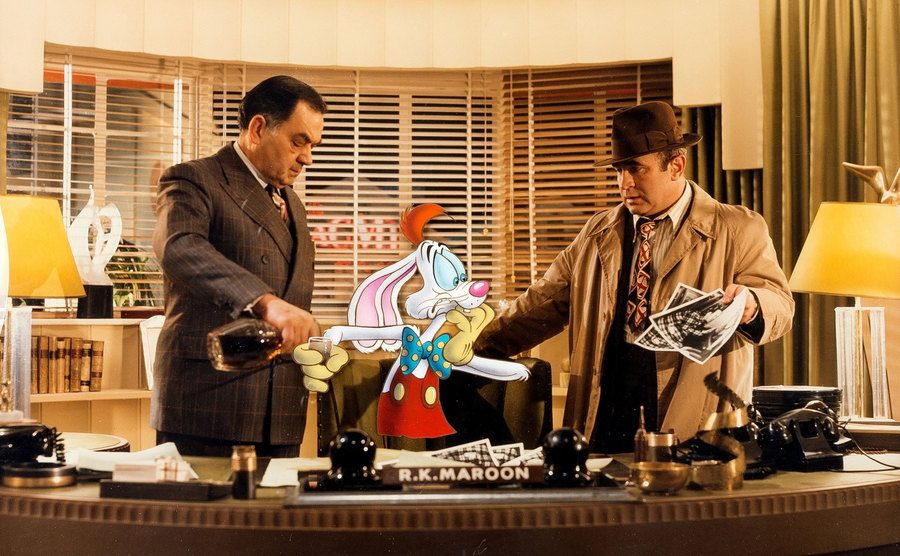 Alan Tilvern, as Maroon, pours a drink for Roger Rabbit in Valiant’s office. 