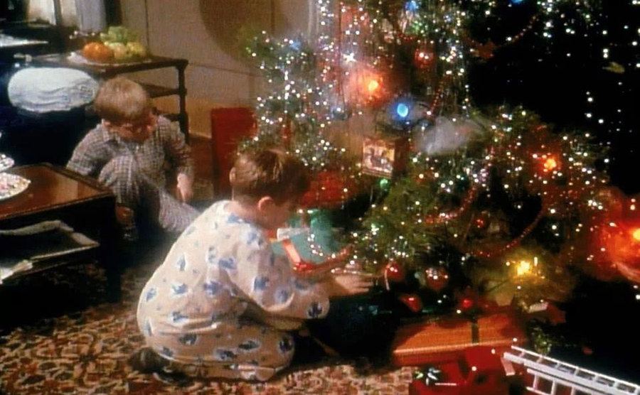 Randy and Ralphie open presents under the Christmas tree. 