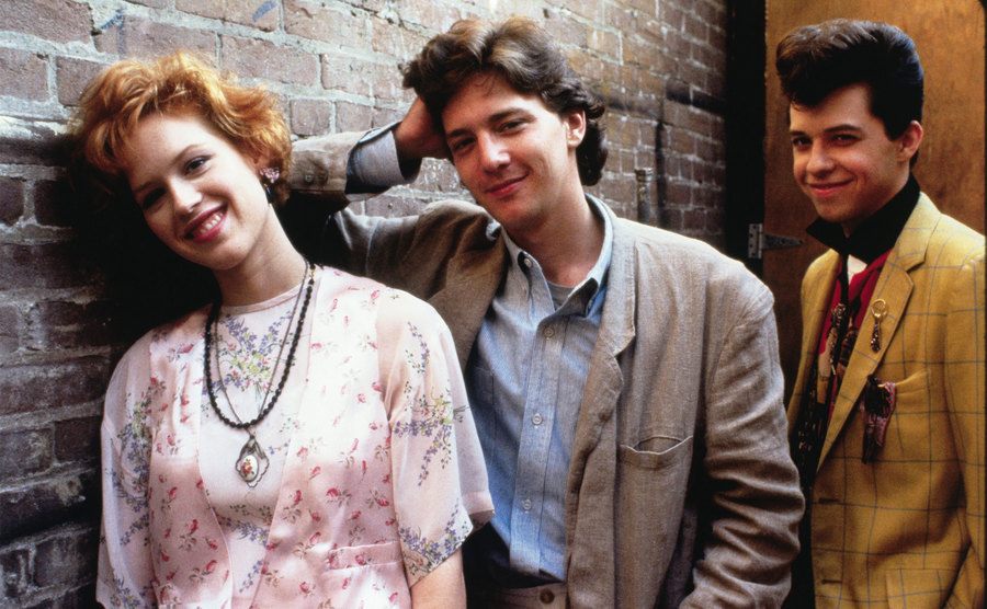 Molly Ringwald, Joh Cryer, and Andrew McCarthy pose as their characters from the film. 