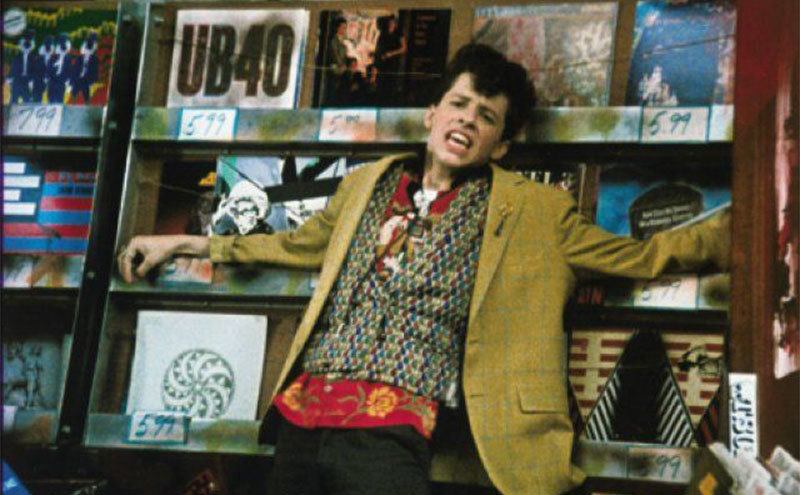 Duckie performs his exaggerated lip-sync in the record shop. 