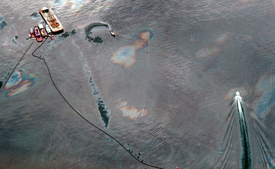 Boats and sorbent boom circle the Exxon Valdez oil spill to control the spreading slicks.