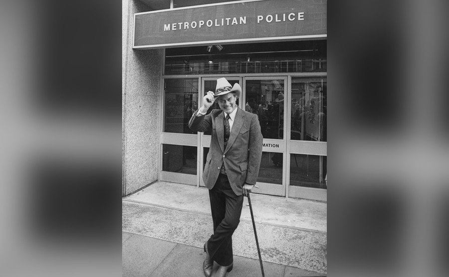 Larry Hagman stands outside the Metropolitan Police, as J.R. Ewing from the soap opera Dallas. 