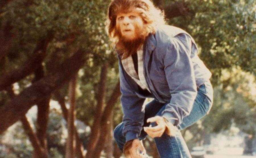 Michael J. Fox is surfing on the roof of his buddy’s van in a still from Teen Wolf. 