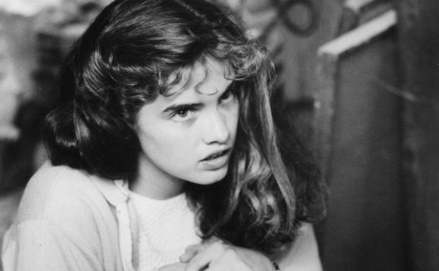 Heather Langenkamp is crouching in a scene from the film.