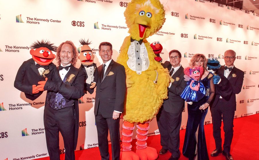 Big Bird and his cohorts, along with their human operators, attend an event.