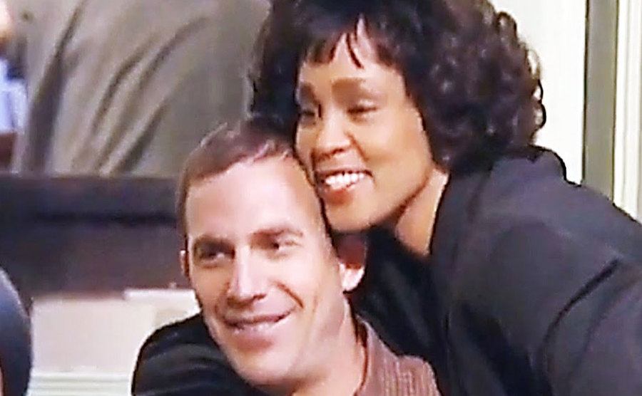 Whitney Houston and Kevin Costner are behind the scenes.