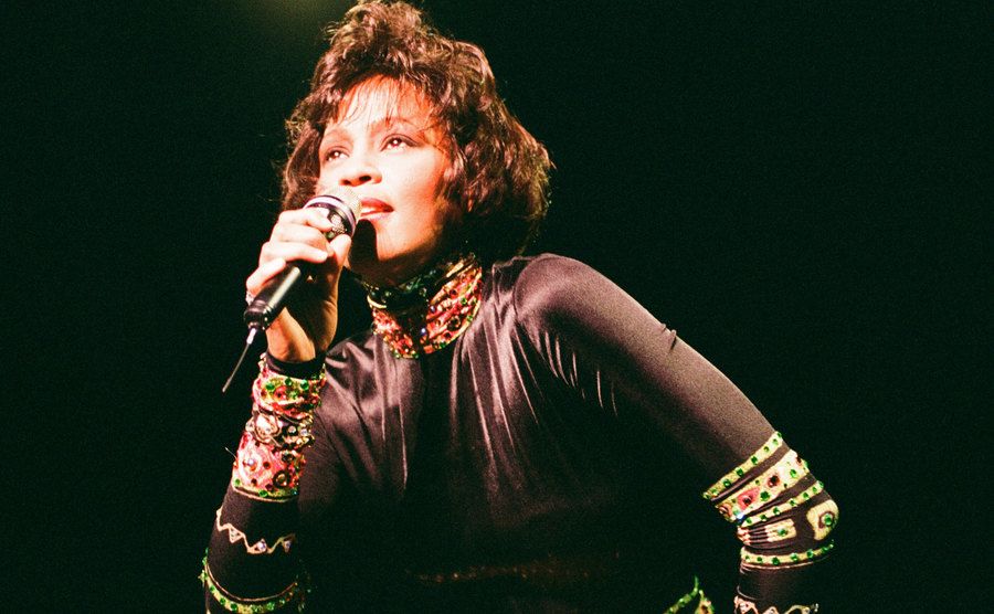 Whitney Houston performs on stage.