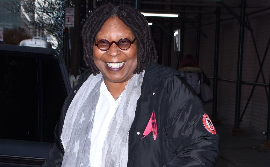 A picture of Whoopie Goldberg walking the street.