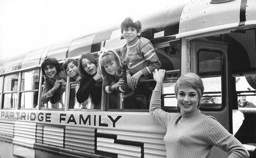 Photo of Partridge Family on their family bus. 