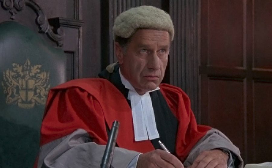 A still of Geoffrey Palmer as a judge.