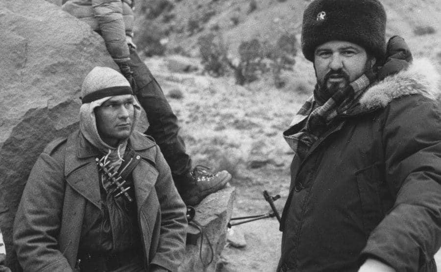 Swayze and Milius are behind the scenes on the set of Red Dawn.