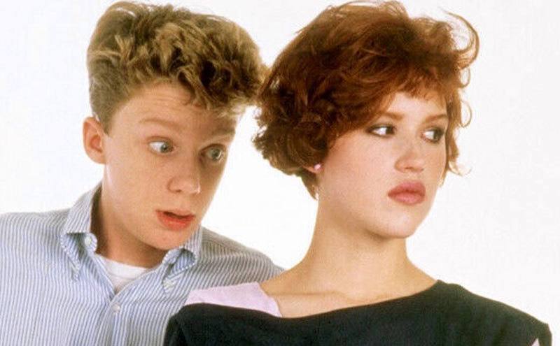 Anthony Michael Hall and Molly Ringwald pose for a studio portrait.