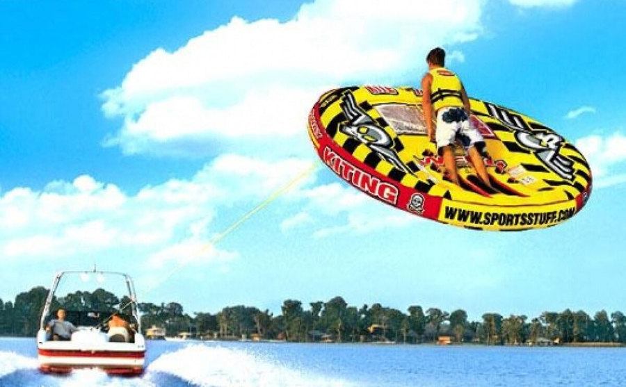 A tube shoot into the air as it is being pulled behind a speed boat. 