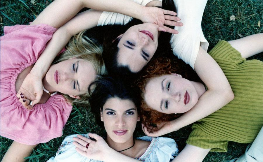 The female cast members of Dazed and Confused lay on the grass. 