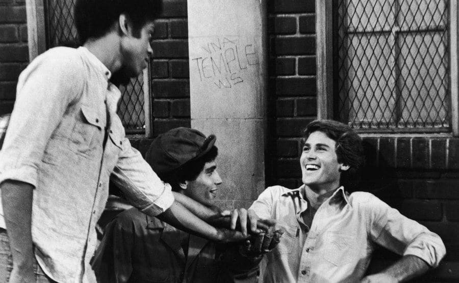Lawrence Hilton-Jacobs, Robert Hegyes, and Stephen Shortridge clasp hands in a still from the television series.