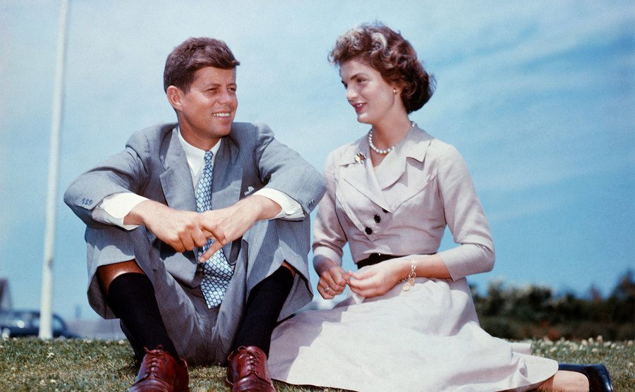 John F. Kennedy and Jacqueline Bouvier sit together in the sunshine at Kennedy's family home