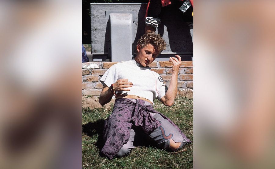 Alex Winter is playing air guitar in a still from the film. 